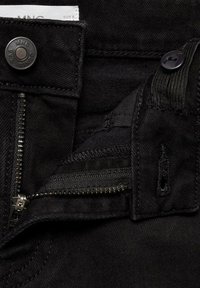 Črne denim hlače z kovinsko zaponko, zadrgo in kontrastnim šivanjem. Tkanina se ponaša z gladko teksturo brez vidnih vzorcev.