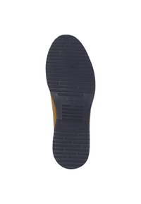 Semelle de chaussure en caoutchouc bleu foncé avec des motifs de grip texturés ; les côtés sont en matériau tan. Un logo de marque est embossé près du talon.