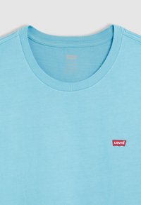 Lichtblauw katoenen T-shirt met een ronde halslijn, met een klein rood Levi's-logo op de linkerborst. Zachte, gladde textuur.