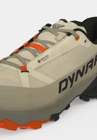 Chaussure de trail Dynafit Gore-Tex beige et orange avec des lacets gris et une semelle noire, dotée d'une semelle crantée robuste pour une utilisation en extérieur.