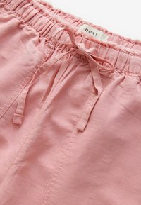 Roze, lichte stof shorts met een elastische tailleband en een voorzijde met strikdetail; heeft een subtiele structuur en stikaccenten.
