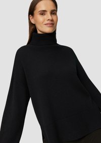 Schwarzer Rollkragenpullover aus strukturiertem Strickstoff. Mit überschnittenen Schultern und einer lockeren Passform, mit gerippten Akzenten am Kragen und Saum.