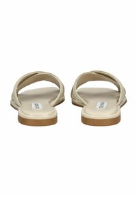 Platte sandalen met twee gebogen banden, gemaakt van beige materiaal. Textuur oppervlak, lichte zool en een glad voetbed in een neutrale kleur.