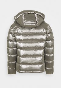 Veste matelassée gris métallique avec capuche, dotée de sections horizontales matelassées et d'une texture brillante et lisse. Détail zippé au niveau du col.
