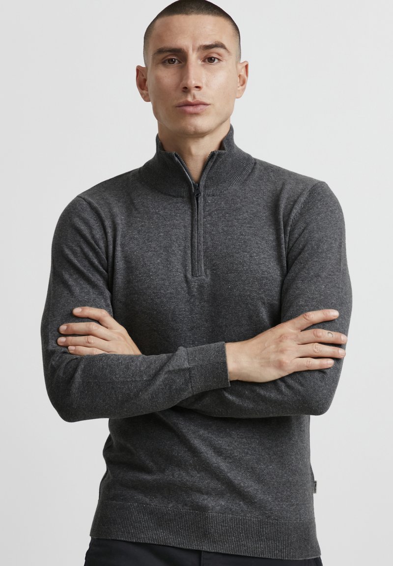Tumedat halli zip-up särk kõrgema kaelusega, soonikute ja alläärega, valmistatud tekstuursetest kudumiskangast, millel on peen muster.