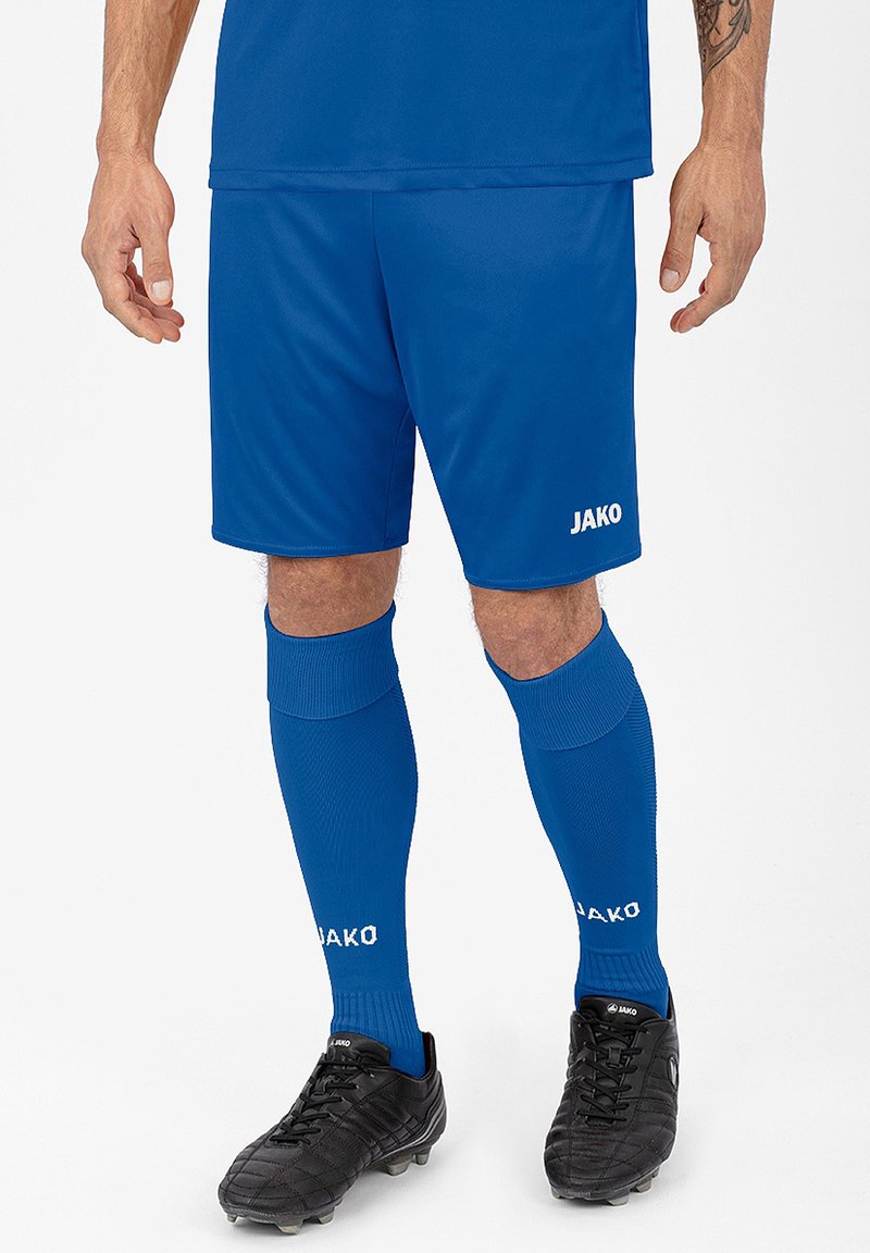 Blaue Sportshorts aus leichtem Material, kombiniert mit passenden blauen kniehohen Socken. Schwarze Fußballschuhe mit strukturierter Oberfläche.