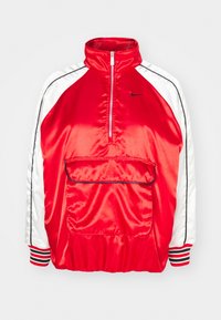 Röd och vit satin jacka med blixtlås och hög krage, stor framficka, svarta detaljer på ärmarna och randiga mudd.