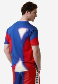 Camiseta con un diseño de degradado en colores azul, rojo y blanco, de manga corta y corte relajado, fabricada en suave material de algodón.