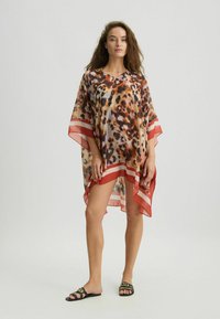 Copertura in stile kimono trasparente con stampa animalier, caratterizzata da scollatura a V, maniche corte e audaci strisce rosse lungo l'orlo.