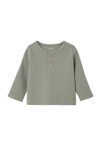 Green long-sleeve shirt in a textured waffle knit, featuring a rounded neckline, two wooden buttons at the front, and a relaxed fit.