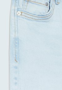 Světlé modré džíny z denimu s klasickým designem, jemným šitím a bronzovým knoflíkem na přední kapse.