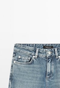 Blå denimjeans med en sliten finish, som har knapplås och dragkedja, femficksdesign och varumärkesetikett på midjan.