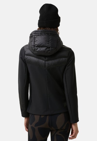 Czarna pikowana kurtka z odpinanym kapturem, stylowym krojem i fakturowanym detalem na ramionach. W zestawie z legginsami we wzory.