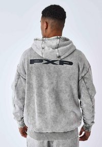 Grijze hoodie met een zachte textuur, voorzien van zwarte "PXP" letters op de achterkant en ribgebreide manchetten en zoom.