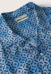 Korte mouwen geweven shirt in verschillende blauwtinten, met een geometrisch patroon, kraag en een knoopsluiting. Regular fit, lichtgewicht stof.