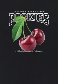 Zwart T-shirt met een grafiek van twee glanzende rode kersen met groene bladeren, boven de tekst "Pookies" en "Mediocre since Forever" in het wit.