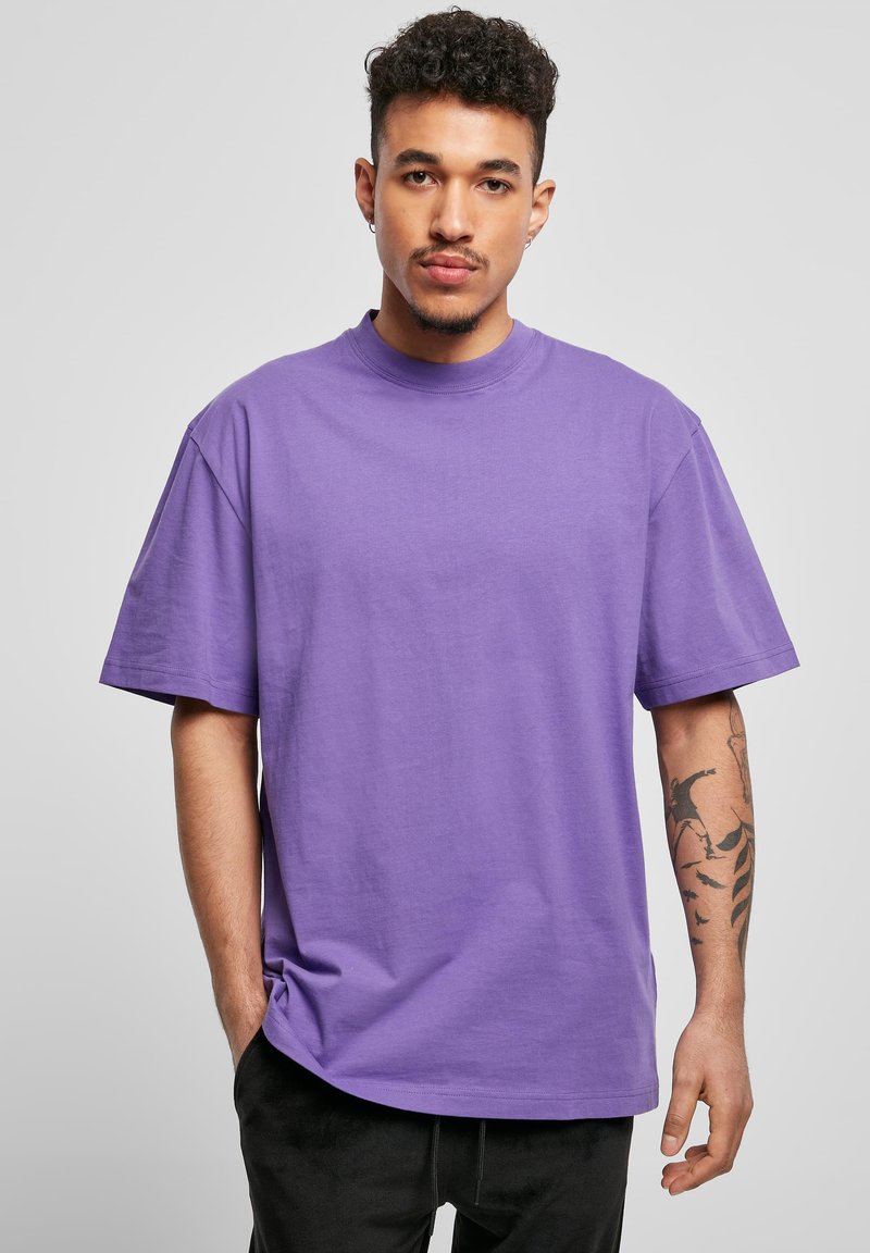 Tricou din bumbac violet cu o croială lejeră, mâneci scurte și gât rotund. Prezintă o textură netedă și o tivă dreaptă.
