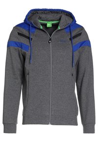 Felpa grigia con zip, decorata con accenti blu e neri, cappuccio con lacci, due tasche laterali e polsini a costine. Realizzata in morbido tessuto testurizzato.