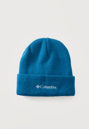 Bonnet bleu tricoté avec revers plié et logo Columbia blanc brodé à l'avant, présenté sur un fond clair uni.