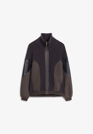 Dzianinowa kurtka na zamek z wysokim kołnierzem, wykonana z ciemnoszarej tkaniny, z skórzanymi akcentami na ramionach i prążkowanymi mankietami dla uzyskania tekstury.