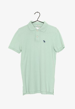 Polo de color verde claro hecho de algodón elástico, con cuello, dos botones y un pequeño logo azul marino en el lado izquierdo.