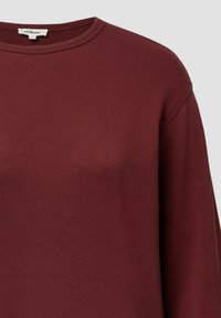 Bordeaux kleurig langemouw shirt met een ronde halslijn, gemaakt van een zachte, gestructureerde stof; heeft verlaagde schouders voor een relaxte pasvorm.