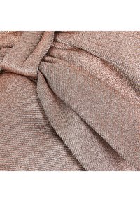 Close-up of folded, textured fabric with a metallic rose gold and silver shimmer.