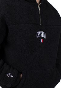 Pullover in fleece nero con zip a un quarto, caratterizzato da ricamo "CRYSTAL" e un accento con la bandiera francese sul petto. Tessuto testurizzato e dettagli con tasca.