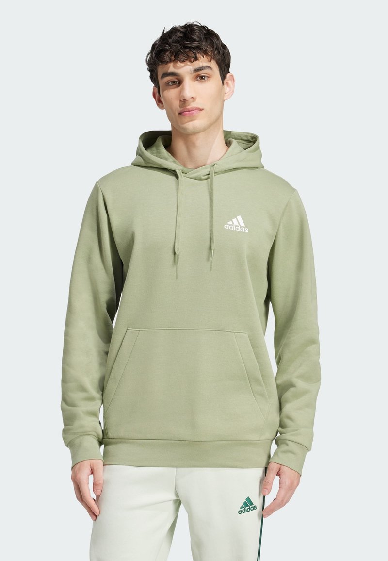 Ljust grön hoodie med känguruficka och vitt logotyp på bröstet. Mjukt material, ribbade ärmslut och fåll.