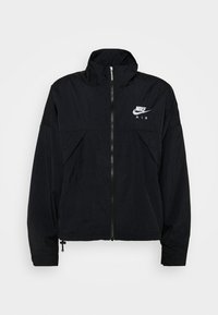 Svart vindjacka med hög krage, dragkedja fram och Nike Air-logotyp. Har paneler och elastiska muddar för en tät passform.