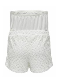 Shorts blancs avec une taille élastique, ornés d'un superposé en dentelle florale ajourée et d'une doublure intérieure douce, présentés à plat sur un fond blanc.
