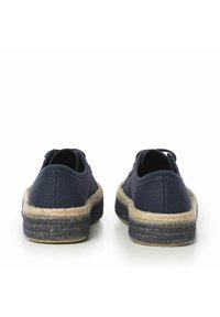 Scarpe in tela blu navy con suola in corda di juta, caratterizzate da un retro basso e un design curvo per il massimo comfort. Stile minimalista con dettagli di cucitura nascosti.