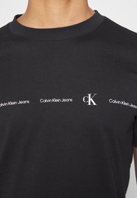 Calvin Klein Jeans REPEAT LOGO TEE UNISEX - T-shirt estampada - black