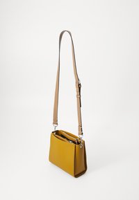 Borsa a tracolla rettangolare gialla realizzata in materiale liscio, dotata di una tracolla beige staccabile e di scomparti multipli per la conservazione.