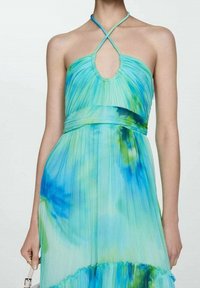 Een geplooide halterjurk met een blauw-groene ombrepatroon, voorzien van een keyhole halslijn en een vloeiende, gelaagde zoom.