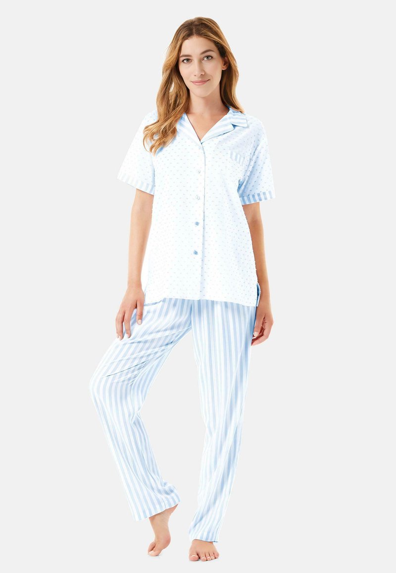 Pijamas de color azul claro que presentan una camiseta de manga corta con lunares y un bolsillo en el pecho, combinados con pantalones a rayas. Tejido suave y fit relajado.