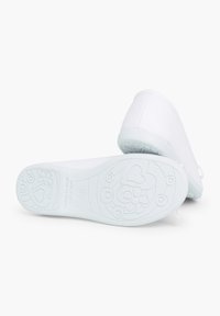 Scarpa in tessuto bianco con punta arrotondata, dotata di una suola in gomma testurizzata decorata con motivi a cuori e fiori.