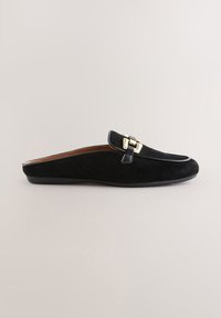 Chaussure à enfiler en daim noir avec bout arrondi et boucle métallique dorée. Doublure en cuir marron lisse. Semelle légère en caoutchouc.