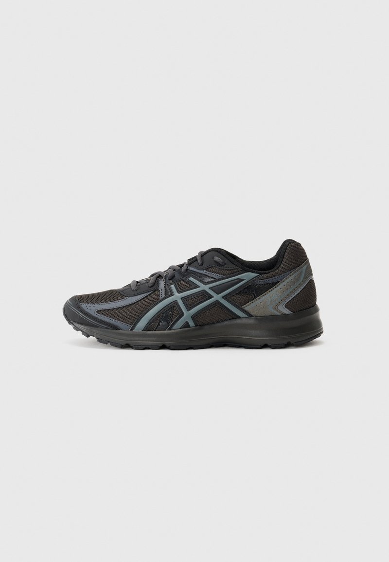 Chaussure de course noire et gris foncé en tissu mesh, fermeture à lacets et semelle en caoutchouc, vue de profil sur un fond clair.
