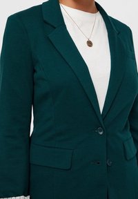 Teal getailleerde blazer van gestructureerde stof, met een geknipt kraag, twee voorkeurszakken en een enkele knoopsluiting.