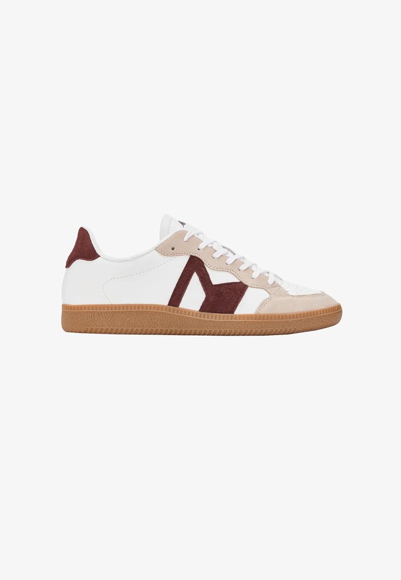 Witte lage sneaker met beige en donkerrode suède accenten, witte veters en een bruine rubberen zool, zijaanzicht naar rechts.