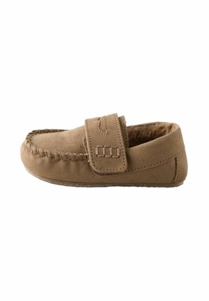 Mocassin en daim beige avec une semelle plate, un orteil arrondi, un détail de broderie et une sangle ajustable sur le dessus. Doublure intérieure douce.