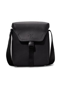 Bolso cruzado de cuero negro con una superficie texturizada, cierre de solapa, correa ajustable y detalle de logo en relieve en la parte frontal.