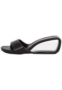 Sandalo con tacco a cuneo nero, superiore in pelle liscia, design con cinturini attorcigliati e tacco angolare trasparente. Soletta piatta con texture minima.