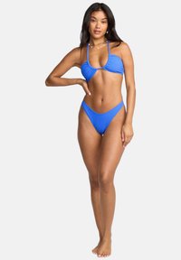 Set di bikini blu a coste con top a collo halter dalla scollatura ampia e slip bikin iltagliati in vita alta. Tessuto liscio, aderente.
