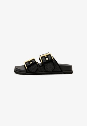 Black slide sandals with double textured straps, gold-colored buckles, and a flat black rubber sole. Designed for comfort and easy wear.
