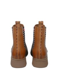 Bottes de cheville en cuir marron avec panneaux en tissu rayé et semelles en caoutchouc nervuré. Présente des coutures contrastantes et des languettes à l'arrière.