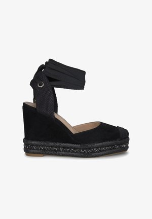 Zwarte wedge espadrille met een gestructureerde suede bovenkant, een omslagband van stof rond de enkel en een gevlochten, met kralen versierde tussenzool.