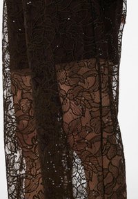 Črna čipkasta ruta z rožnatimi vzorci, okrašena s svetlečimi perlicami, polprosojna z mehkim, teksturiranim zaključkom.