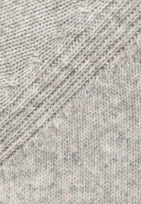 Hellgraues gestricktes Material mit einer strukturierten Oberfläche und diagonalen Rippmustern, das weiche Fasern und leichte Farbtonvariationen aufweist.